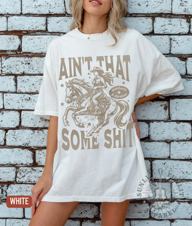 A woman wearing a white t-shirt with a graphic design of a cowboy riding a horse and the text